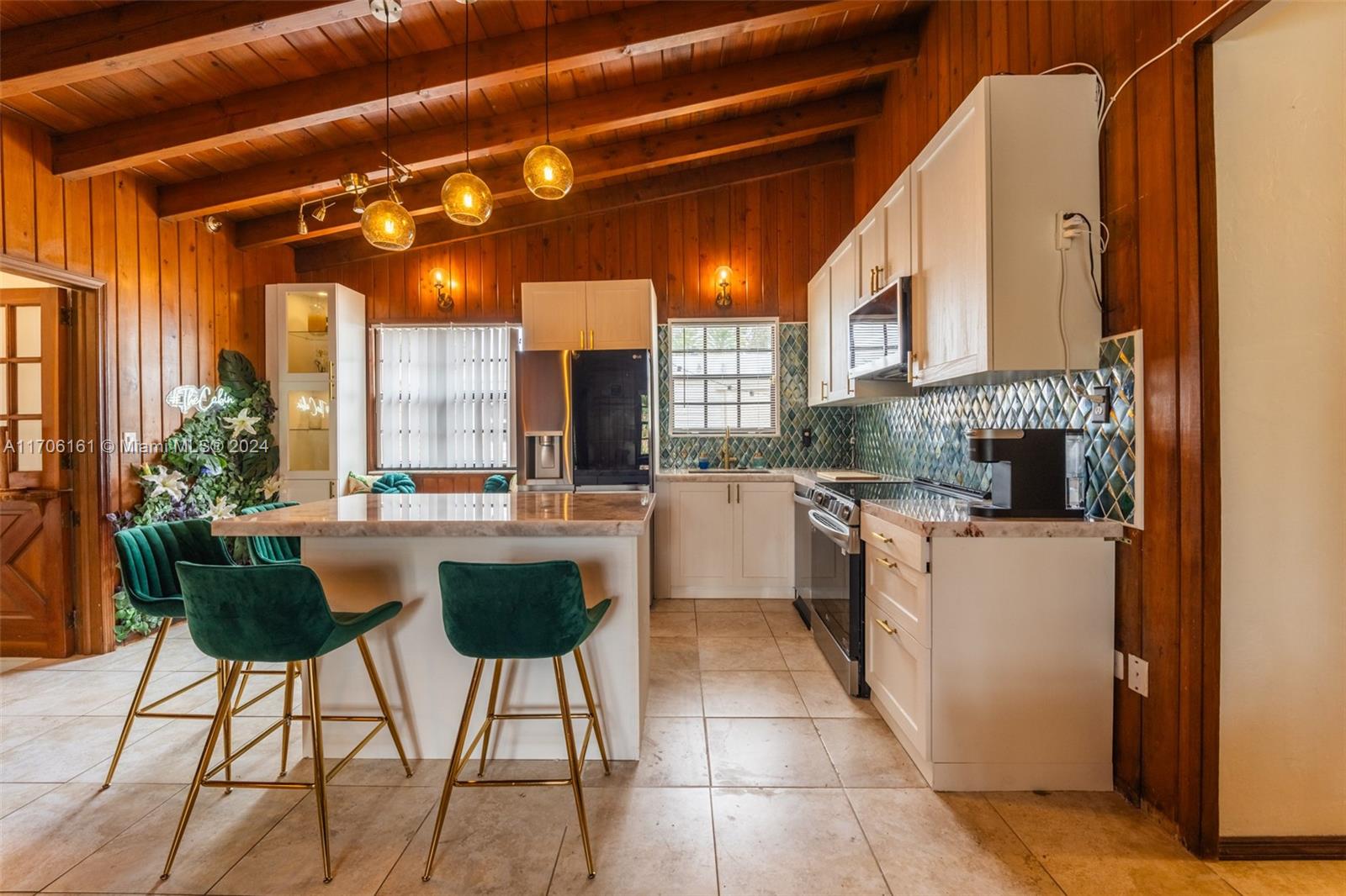 a kitchen with stainless steel appliances kitchen island a table and chairs in it