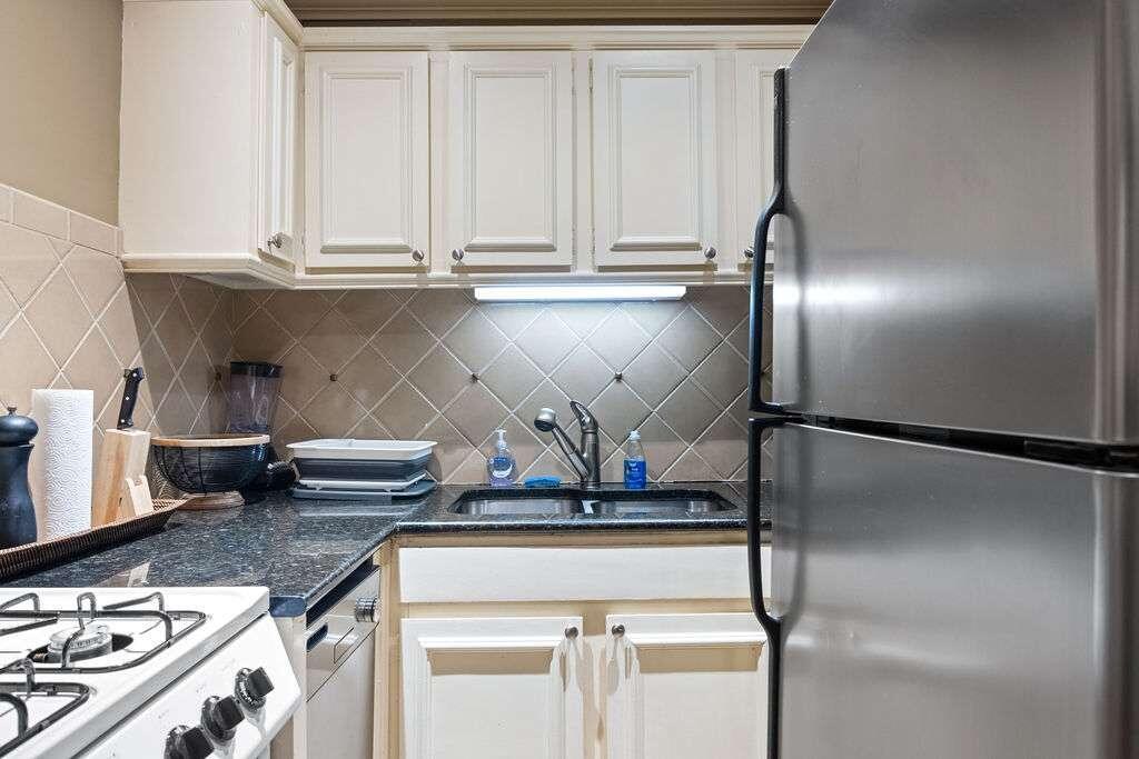 a kitchen with a refrigerator and white cabinets