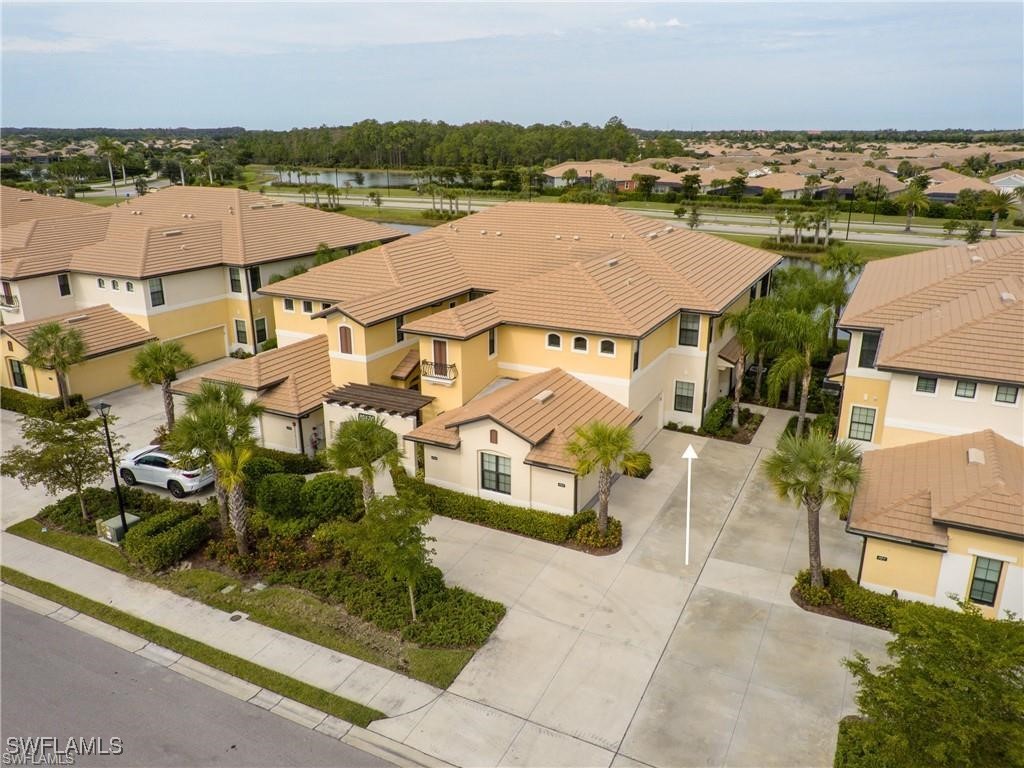 an aerial view of a residential houses with outdoor space and lake view