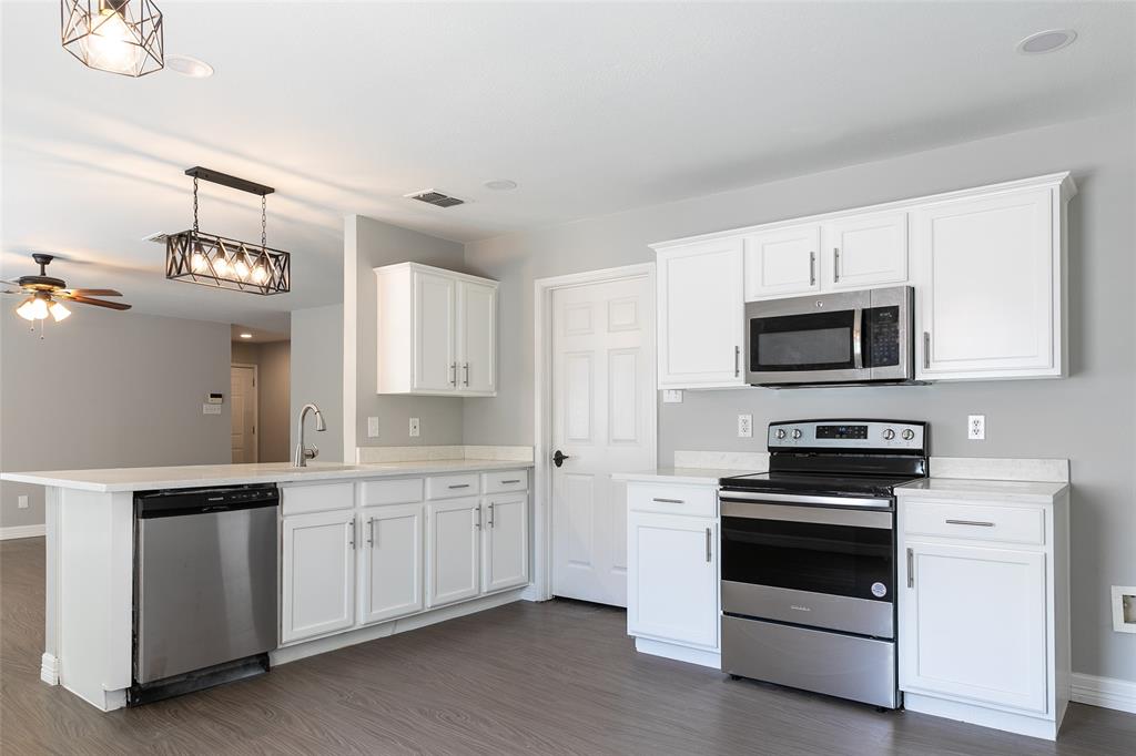 a kitchen with white cabinets and white appliances