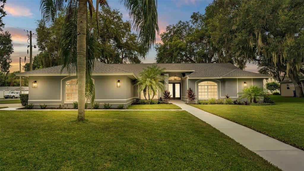 a view of a house with a yard and tree s