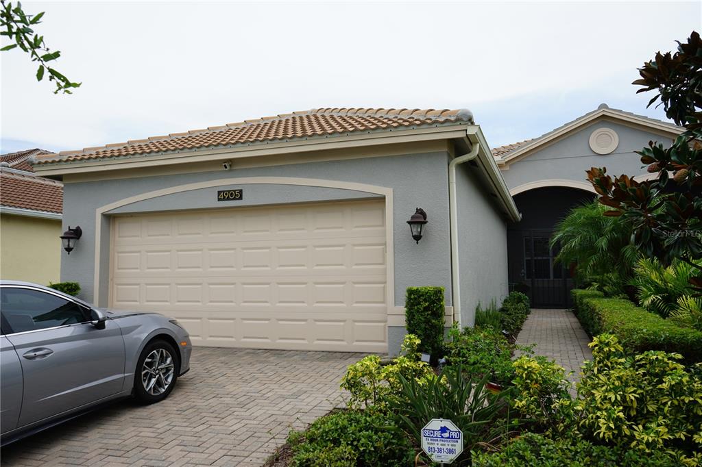 a view of a house with a garage and furniture