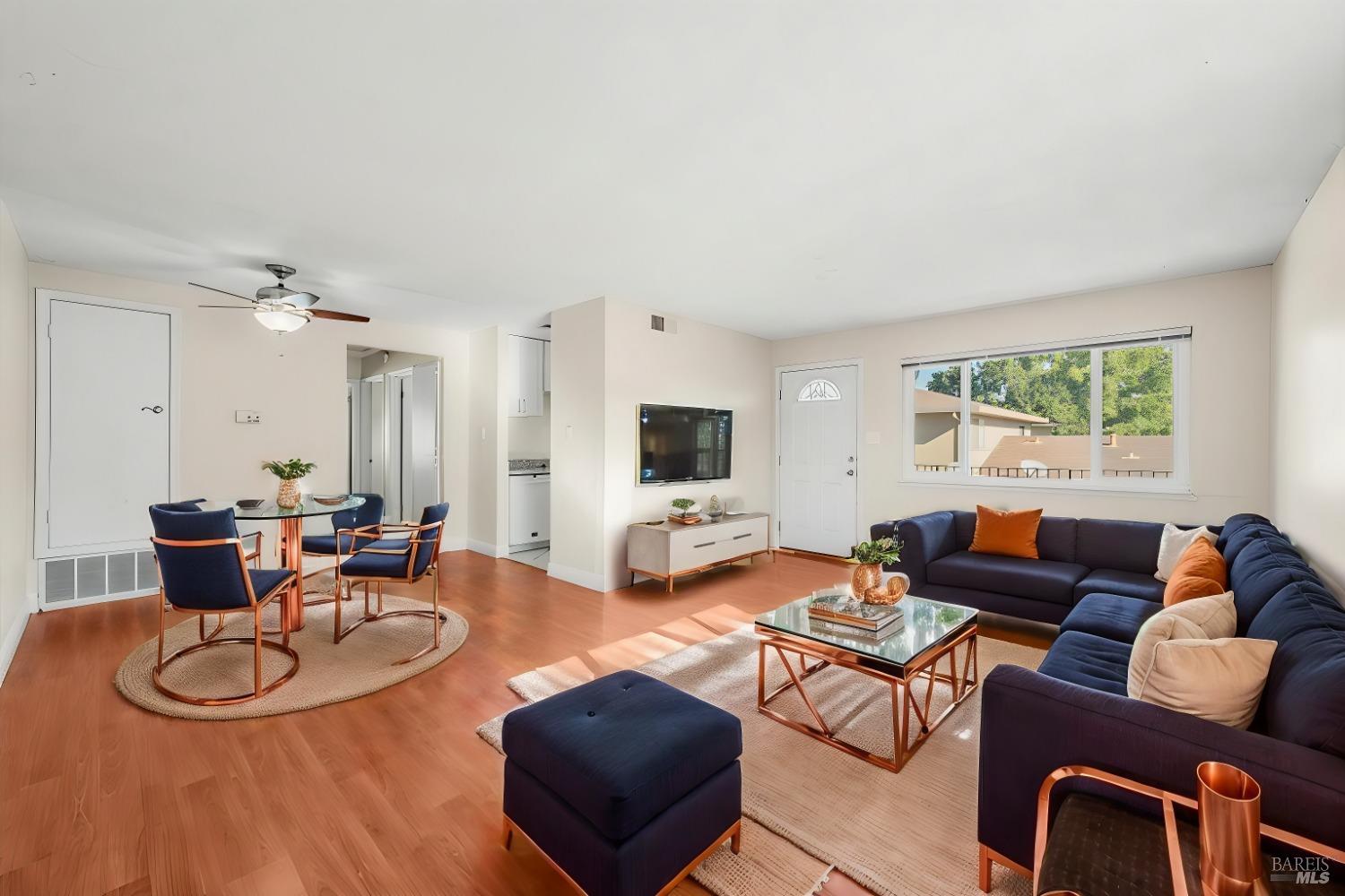 a living room with furniture a large window and a flat screen tv