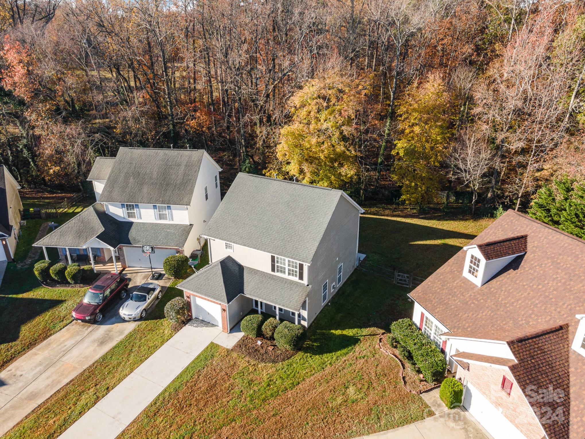 an aerial view of a house with swimming pool and trees