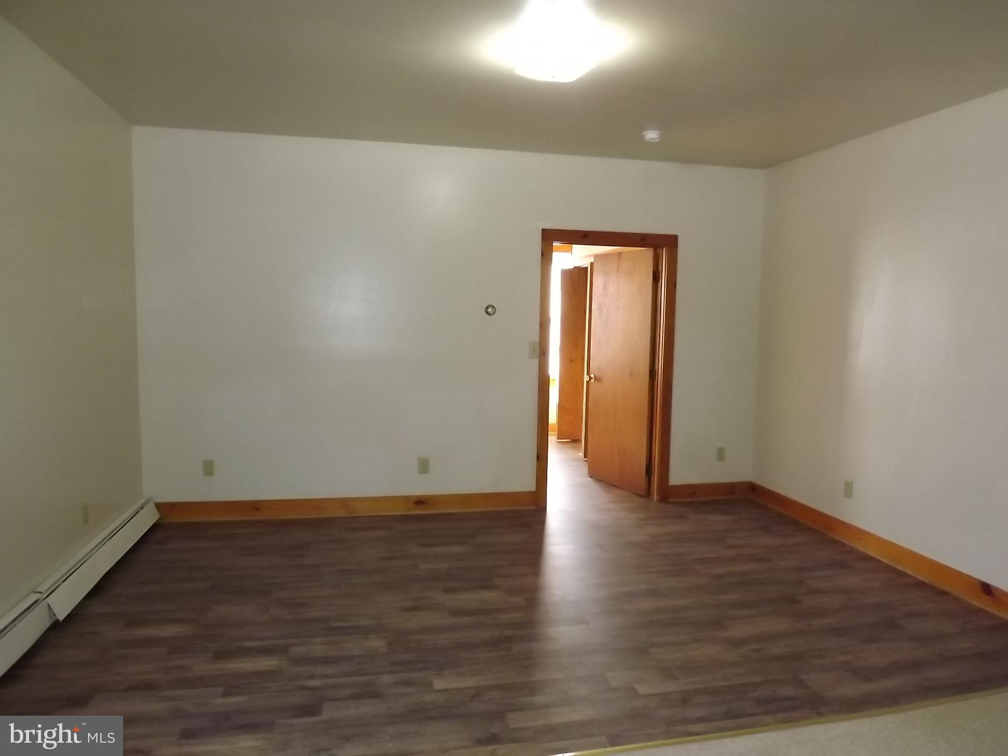 an empty room with wooden floor and closet