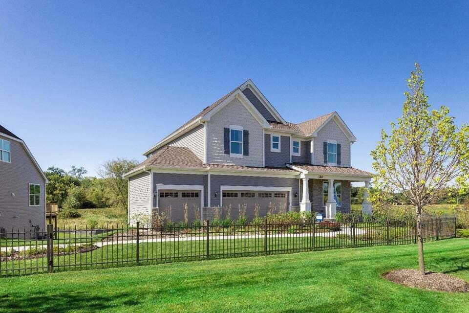 a front view of a house with a garden and trees