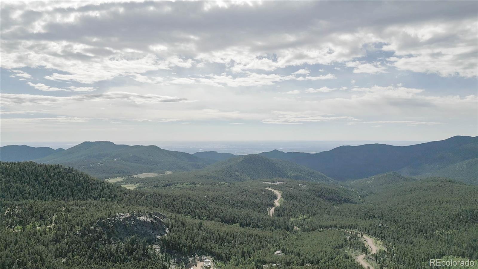 a view of a mountain range with lush green forest