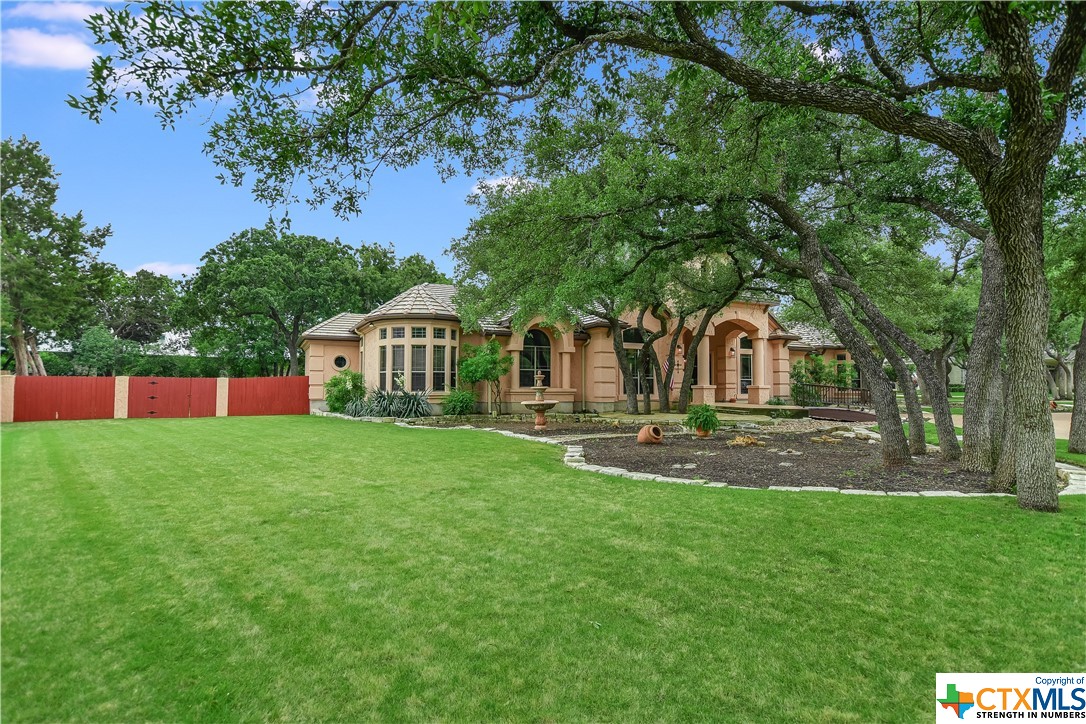 a front view of a house with a garden and trees