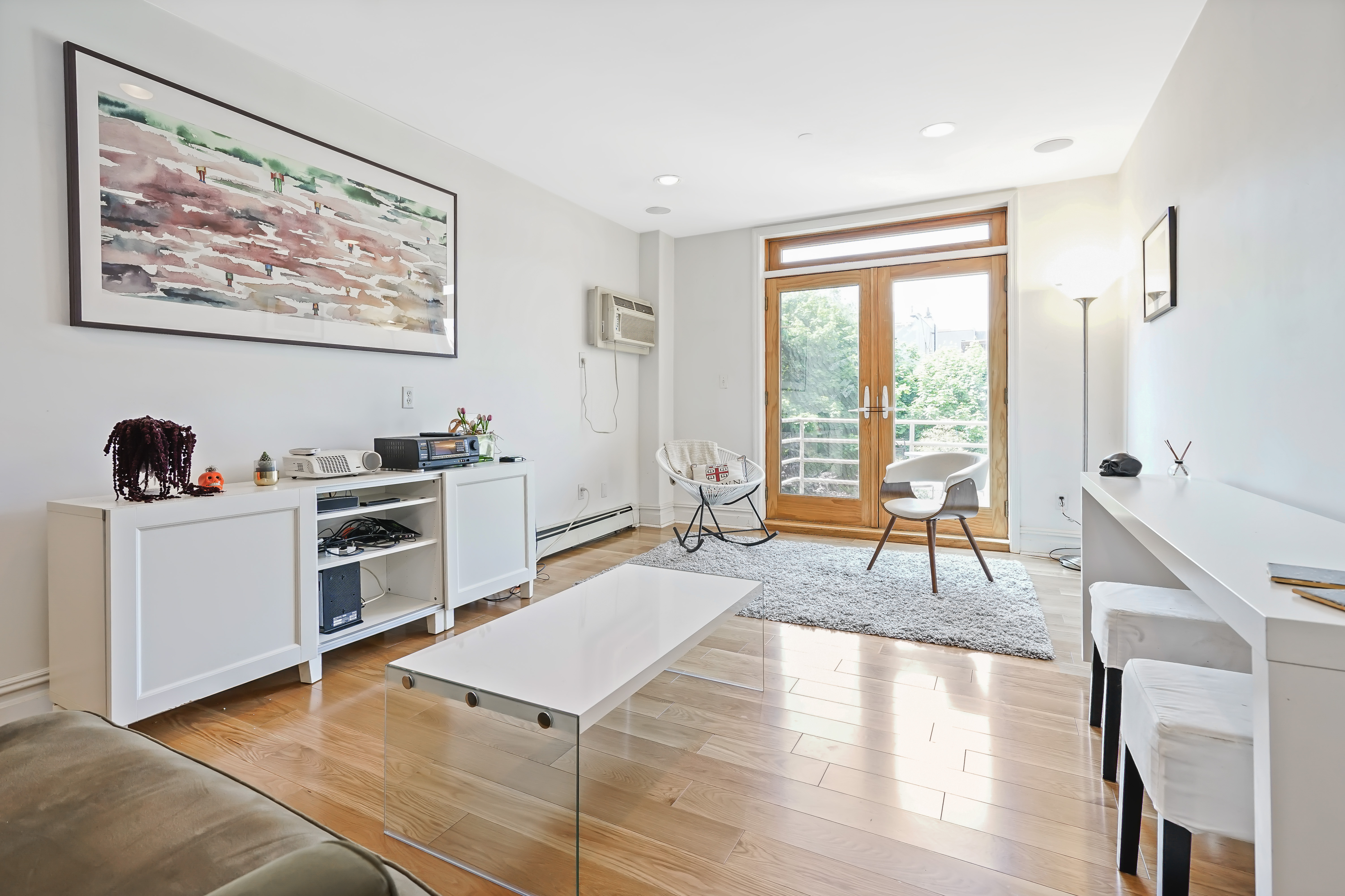 a living room with furniture a wooden floor and a large window