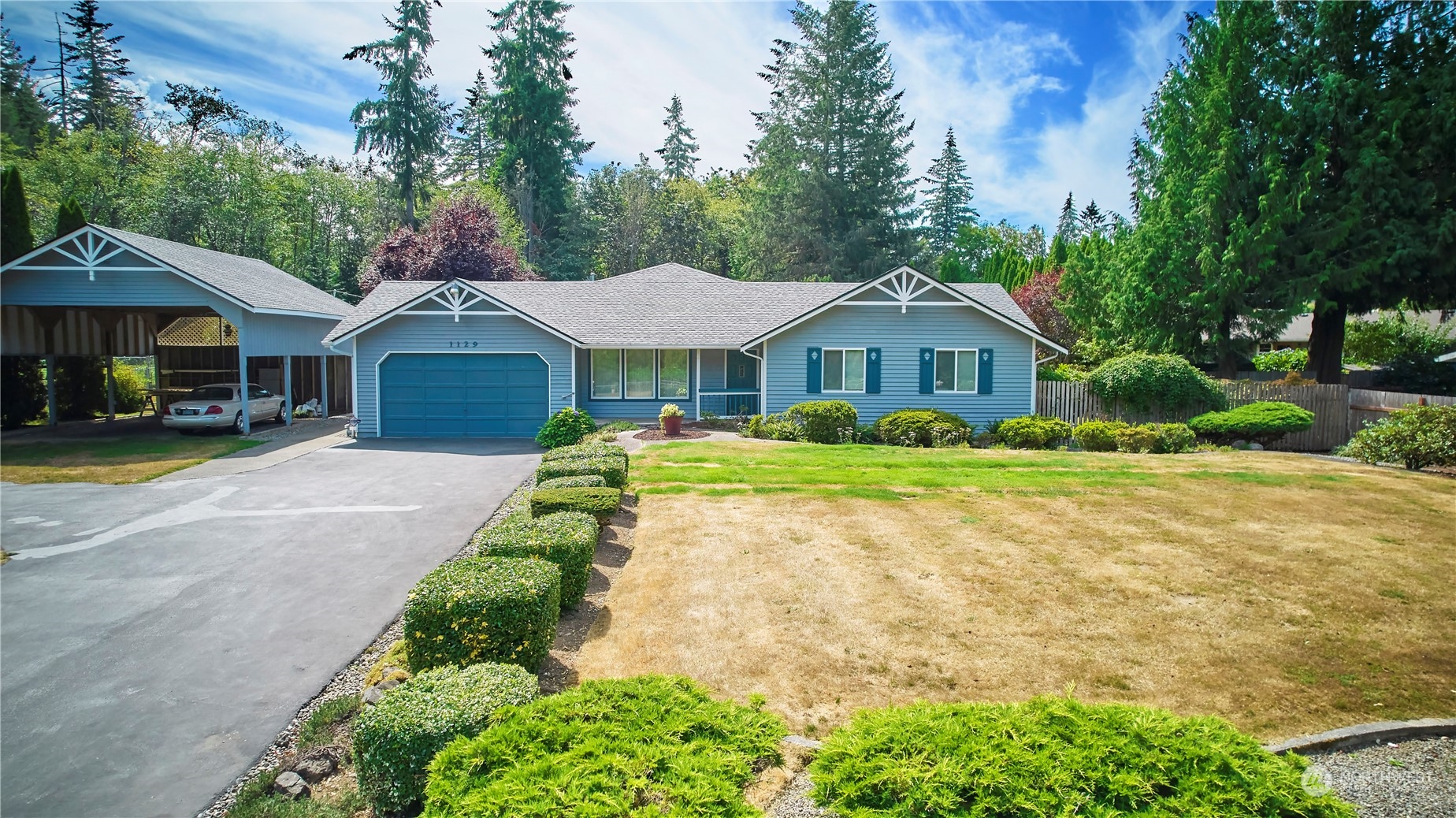 a front view of a house with a yard and trees