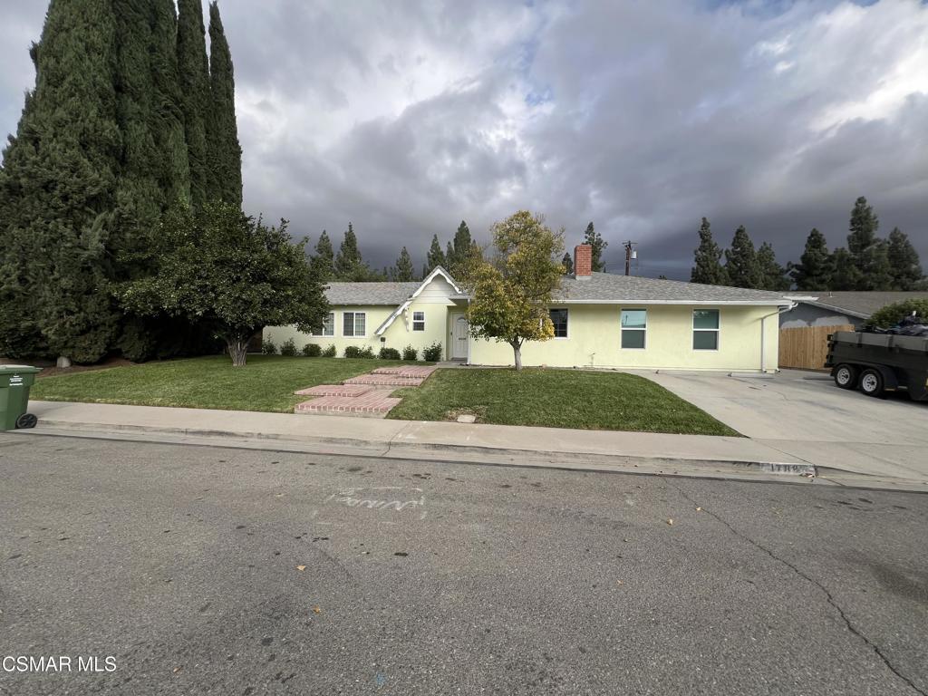 a view of house with a yard and palm trees