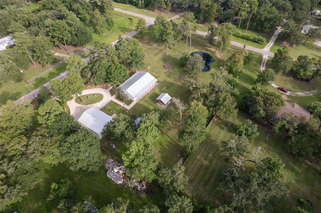 an aerial view of residential house with outdoor space and trees all around