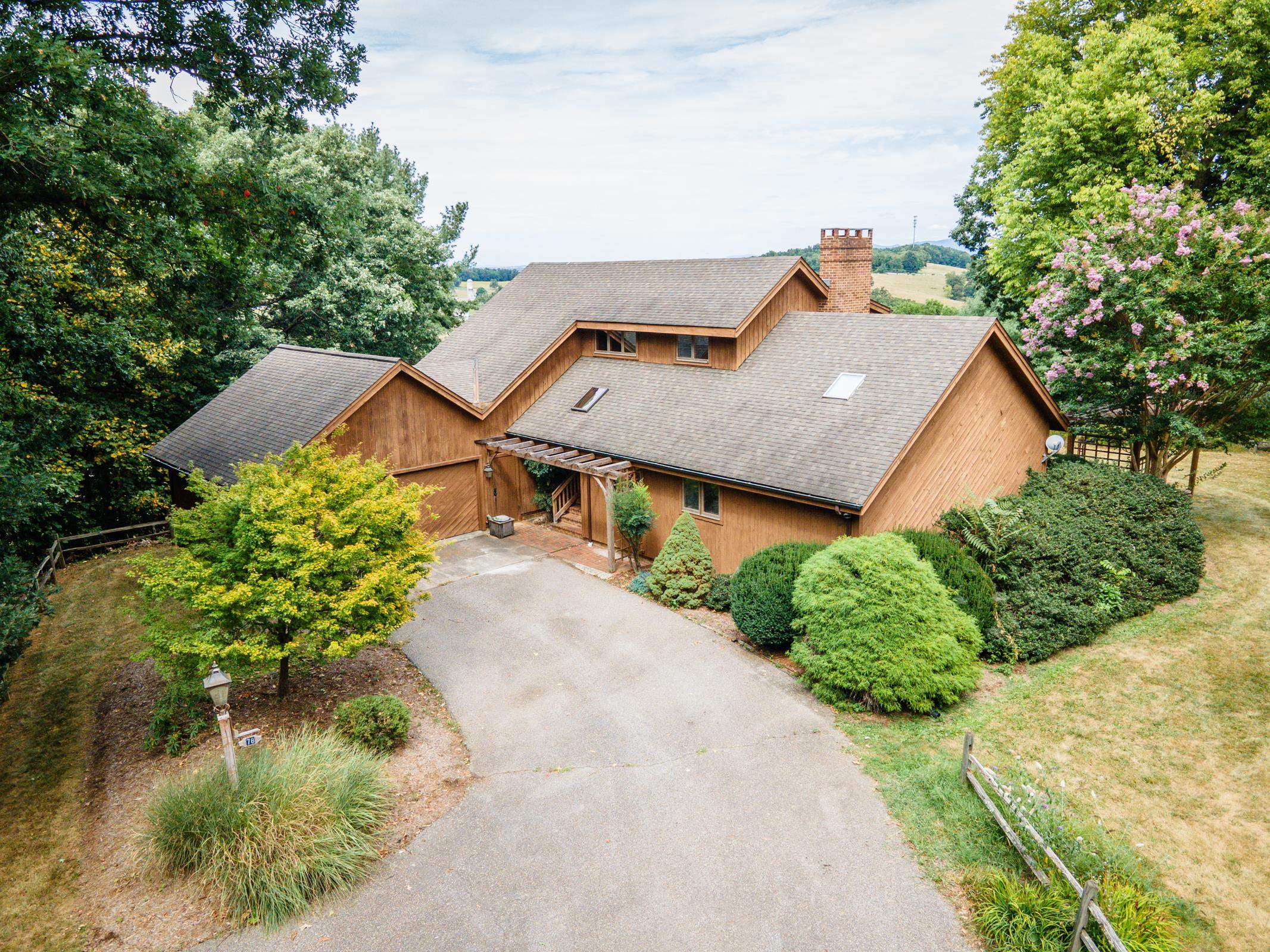 an aerial view of a house with a yard and large trees