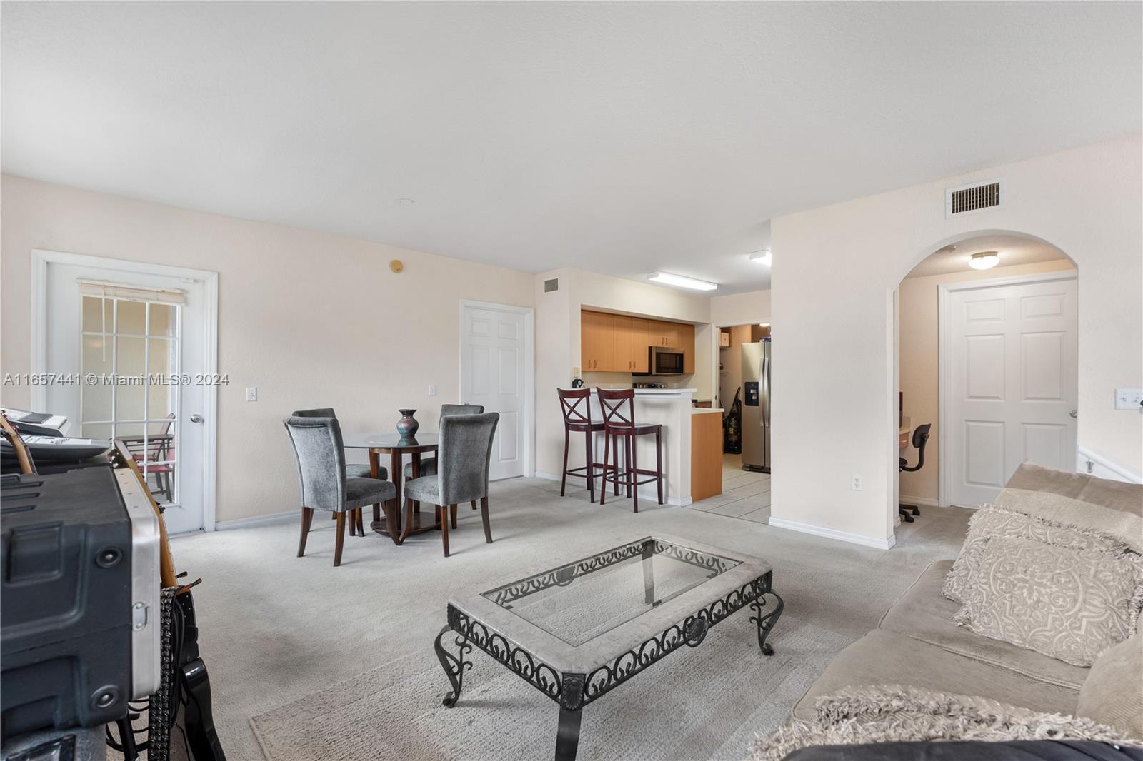 a living room with furniture and kitchen view