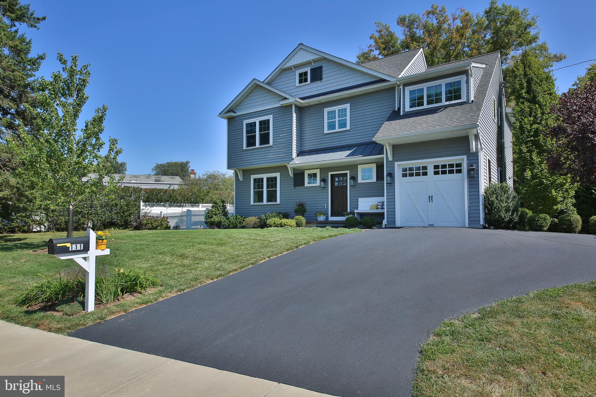 a front view of a house with a yard and trees