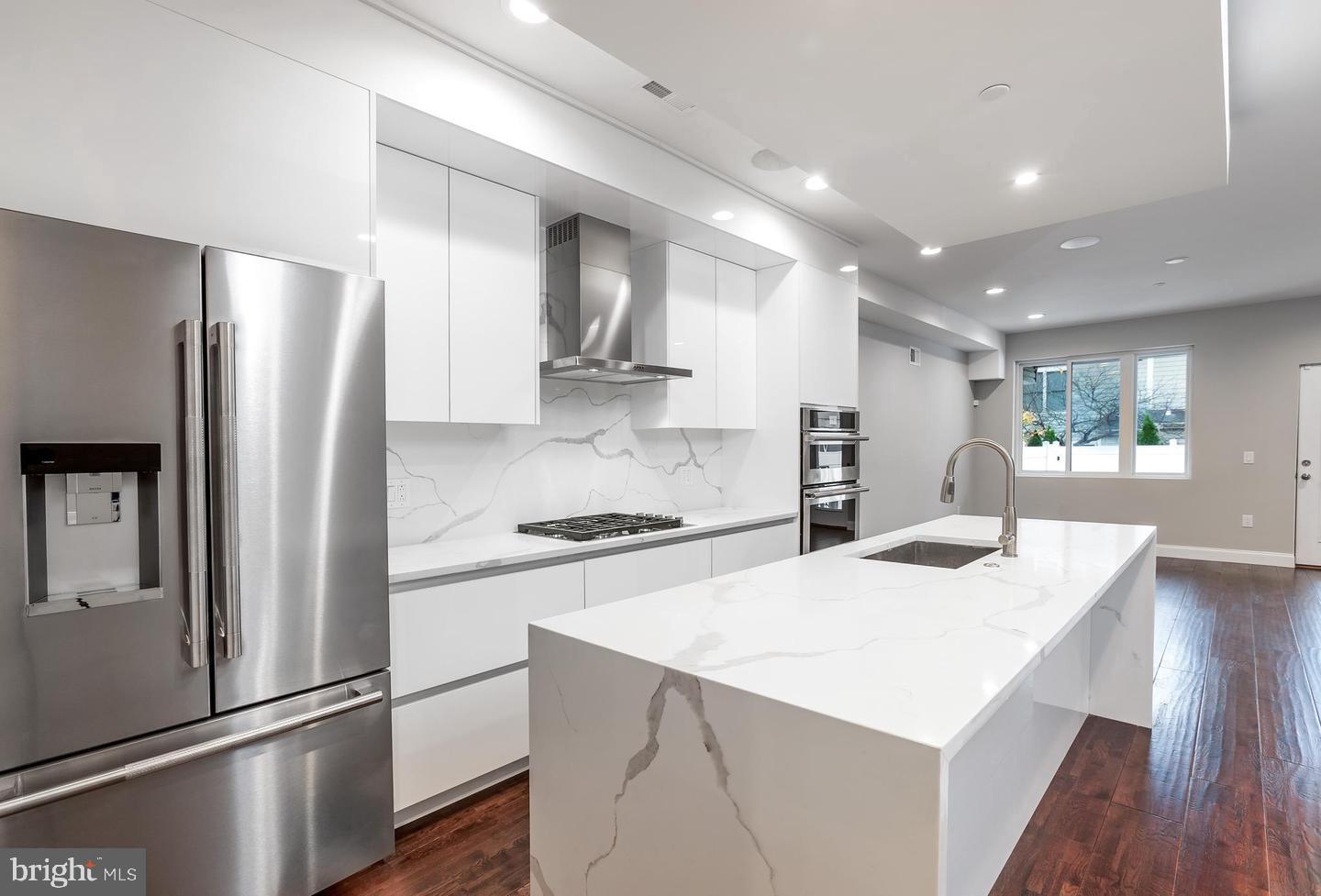 a kitchen with stainless steel appliances a refrigerator sink and stove