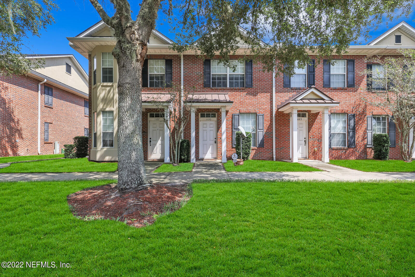 front view of a brick house with a yard