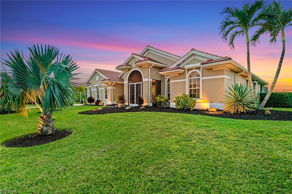 a front view of a house with a garden and trees