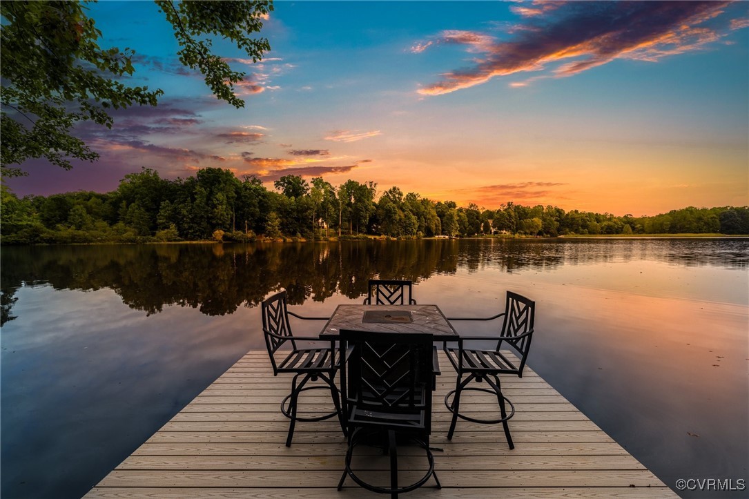 a table and chairs on a deck with a lake view