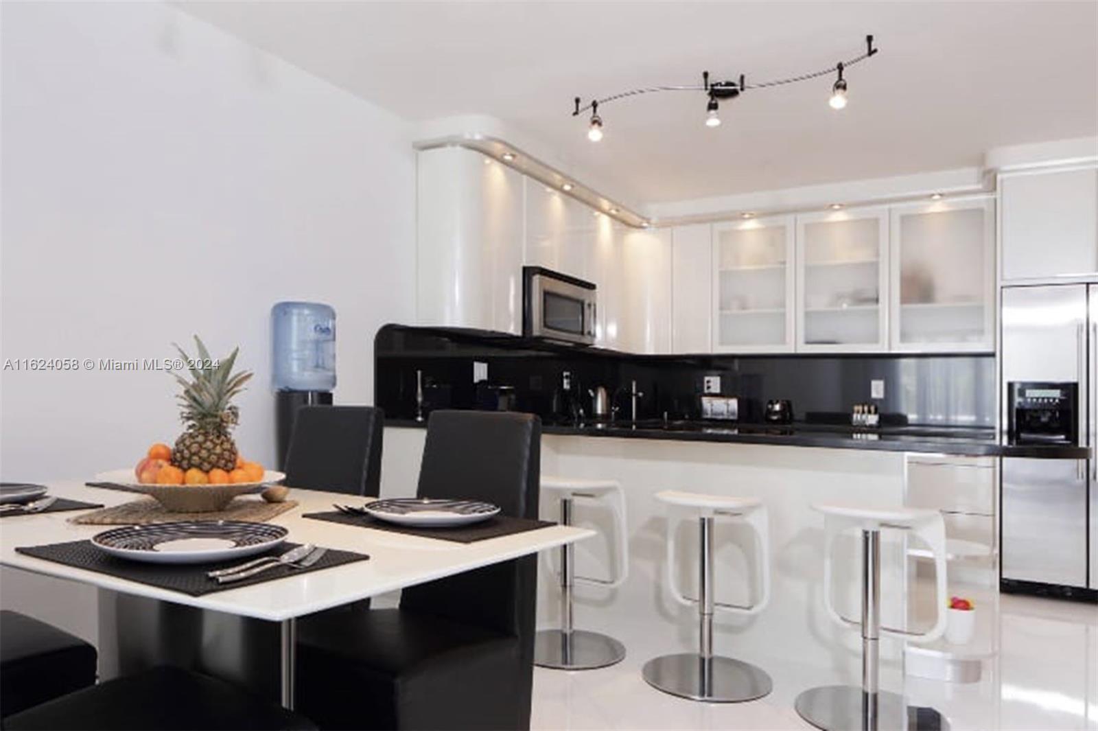 a kitchen with a dining table chairs and white appliances