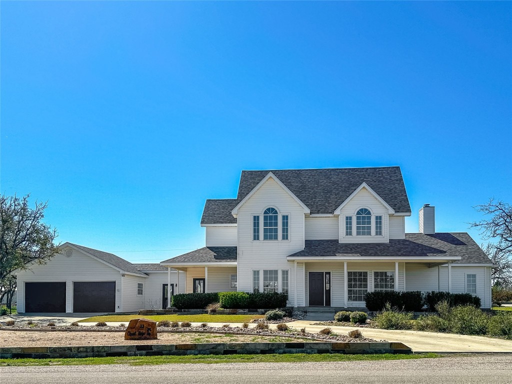 a front view of a house with a garden and parking