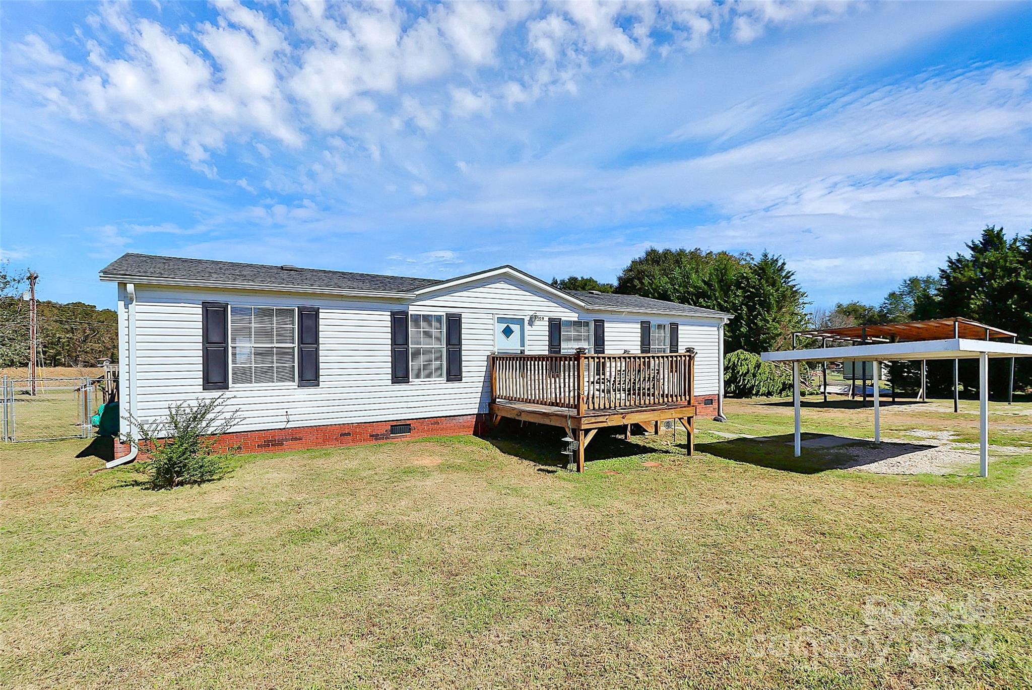 a view of house with swimming pool and yard