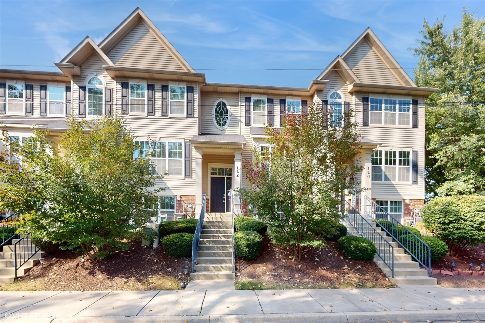 a front view of a house with a yard and potted plants