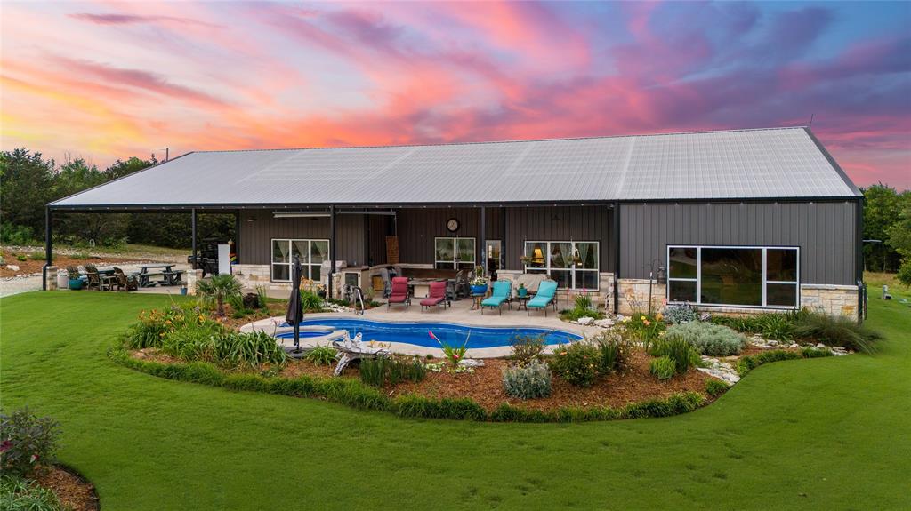 a view of a house with a swimming pool and a yard with plants