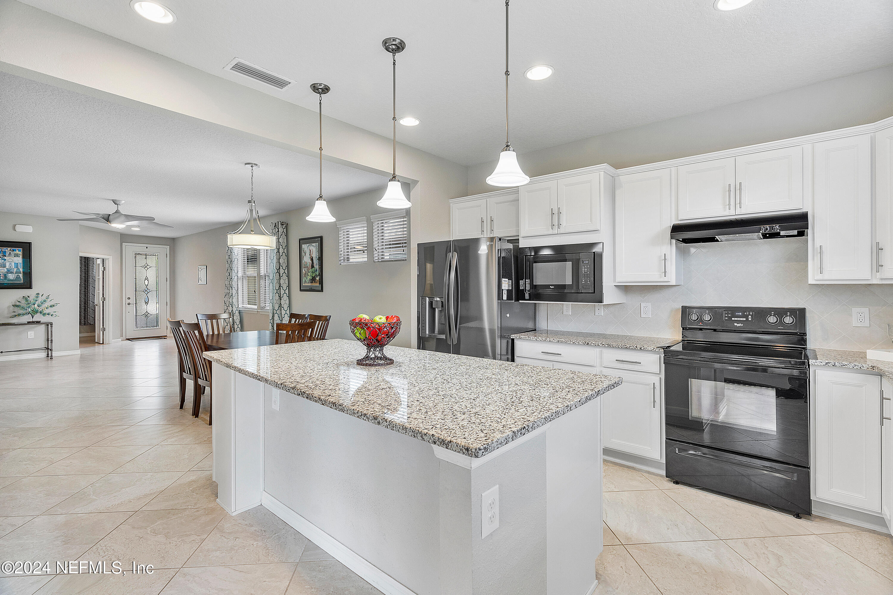 a kitchen with stainless steel appliances granite countertop wooden cabinets a sink a center island and stove