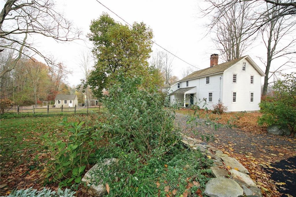 a view of a white house with a big yard and large trees