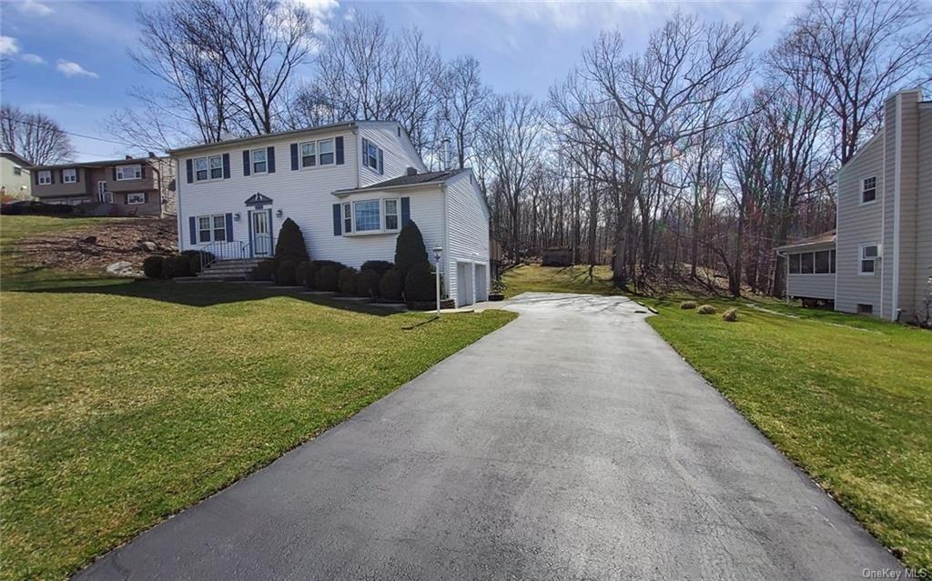 a front view of house with yard and green space