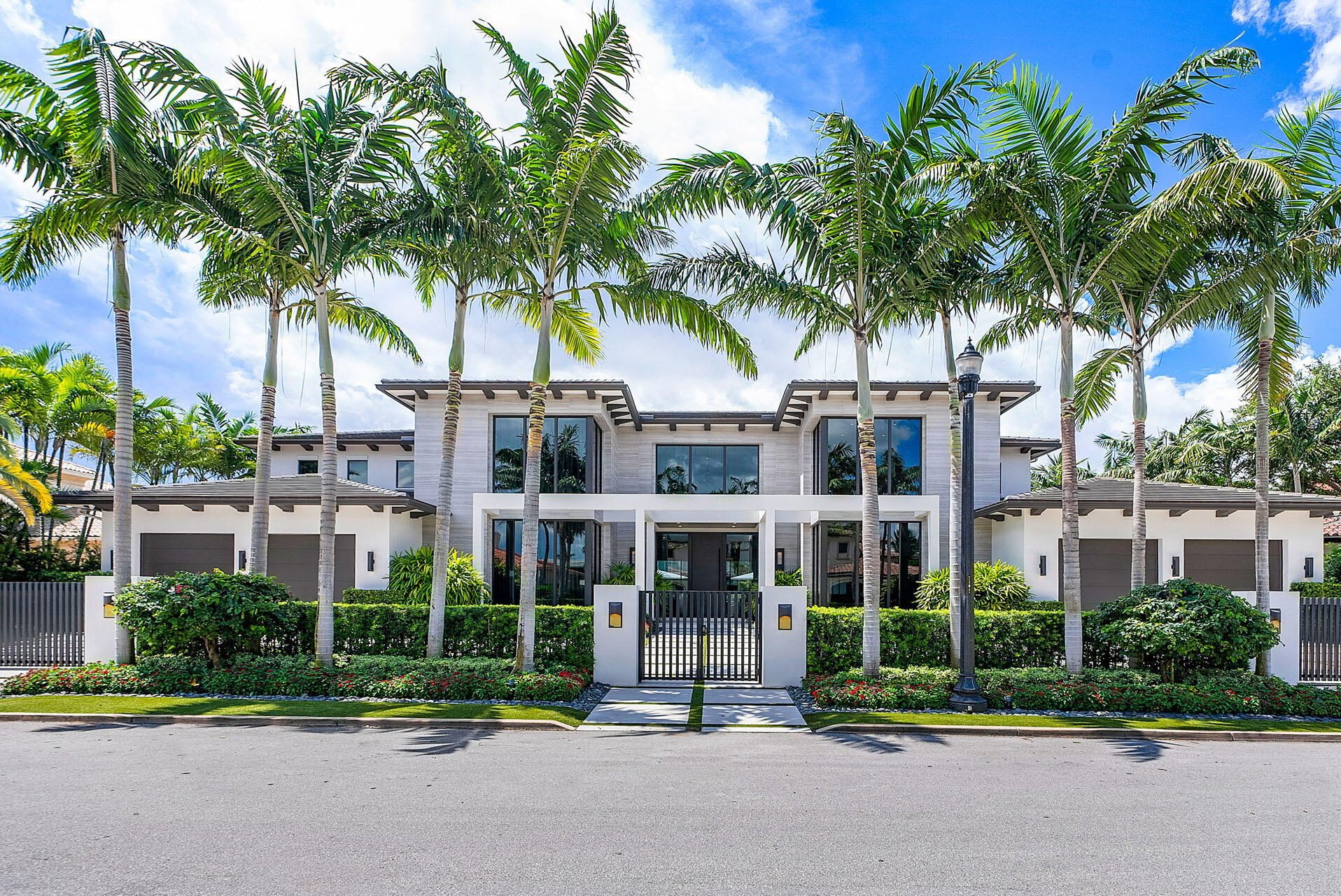 a view of multiple houses with a yard and palm trees