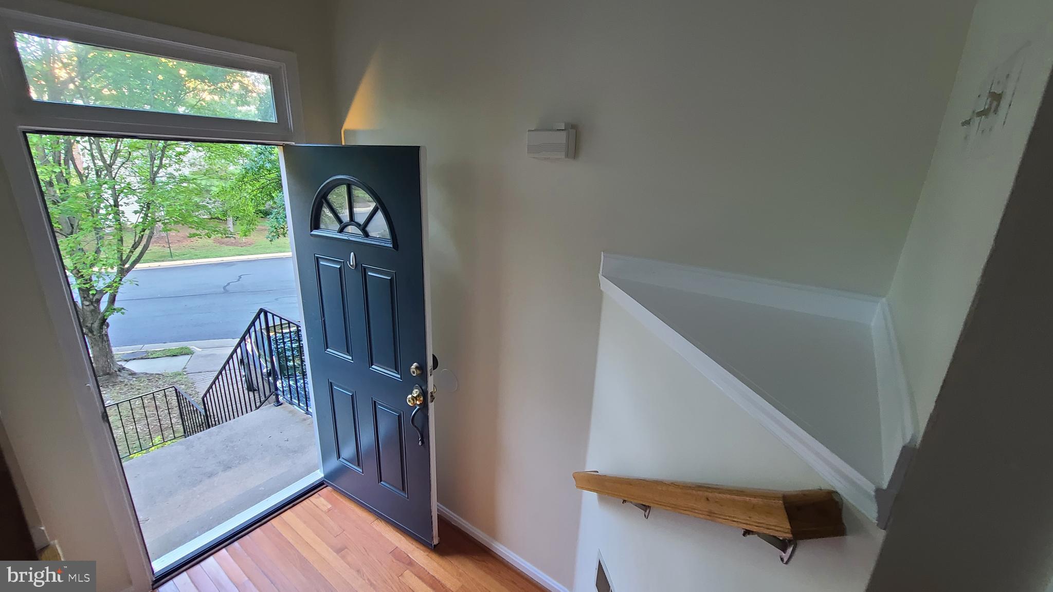 a view of entryway and hall with wooden floor