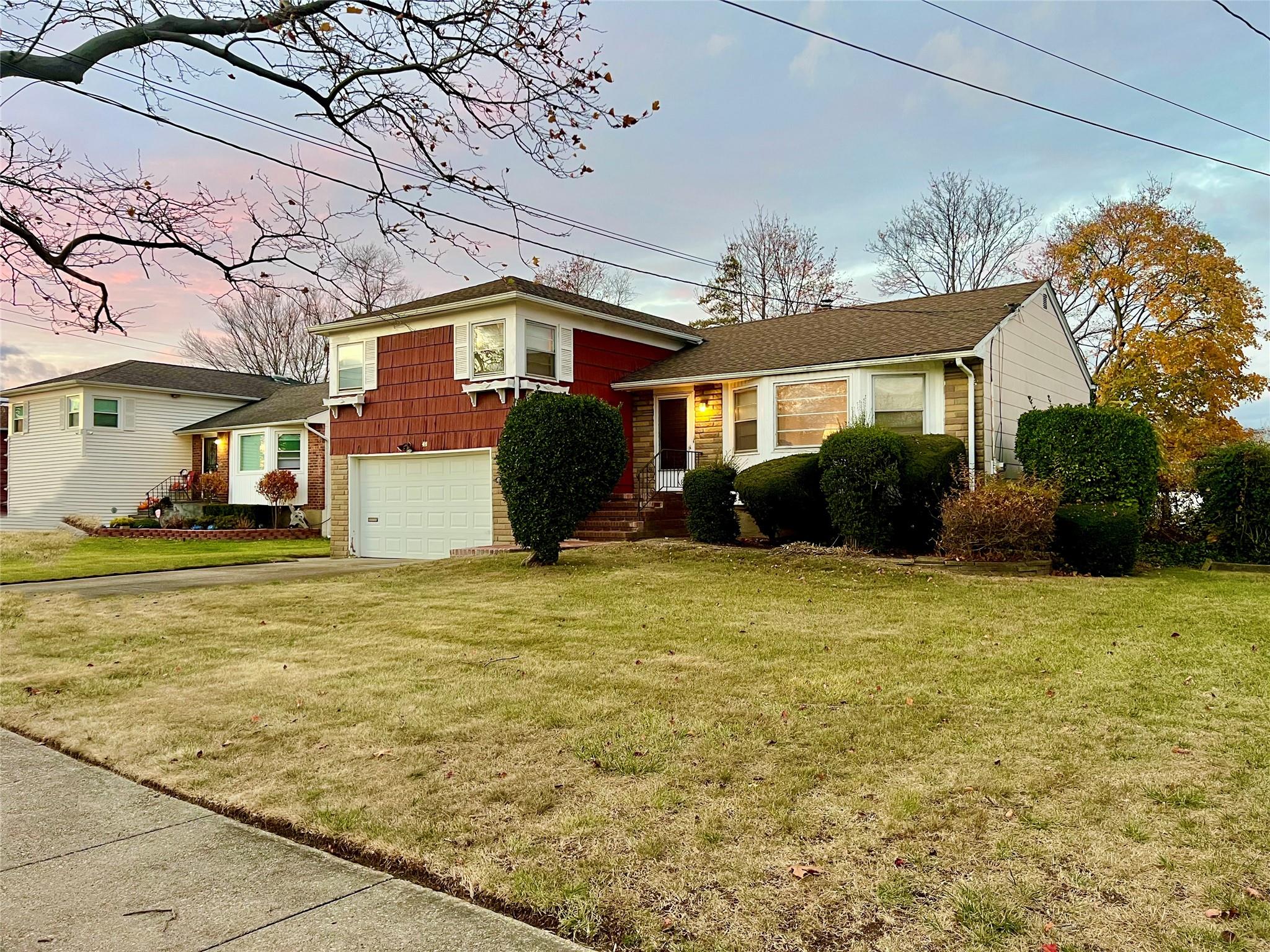 Tri-level home with a lawn and a garage