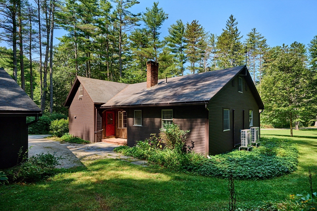 a front view of a house with a yard and trees