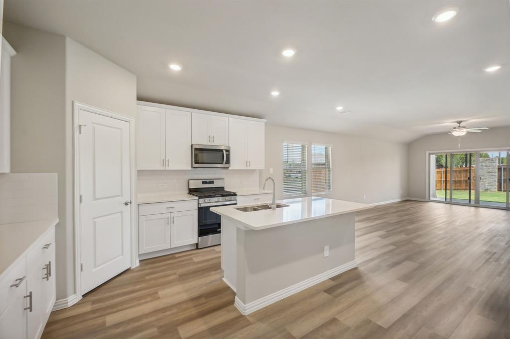 a large kitchen with stainless steel appliances granite countertop a lot of counter space and wooden floor