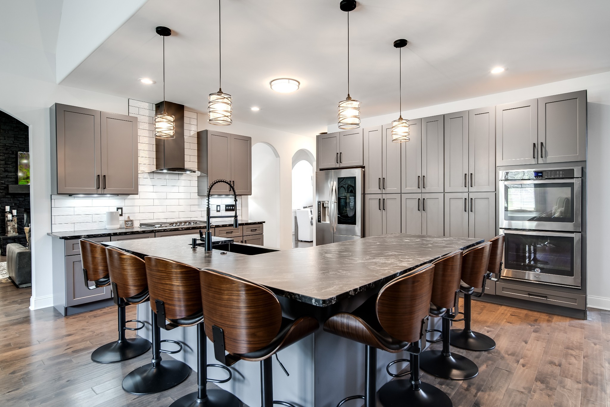 a kitchen with granite countertop a table chairs stainless steel appliances and wooden floor