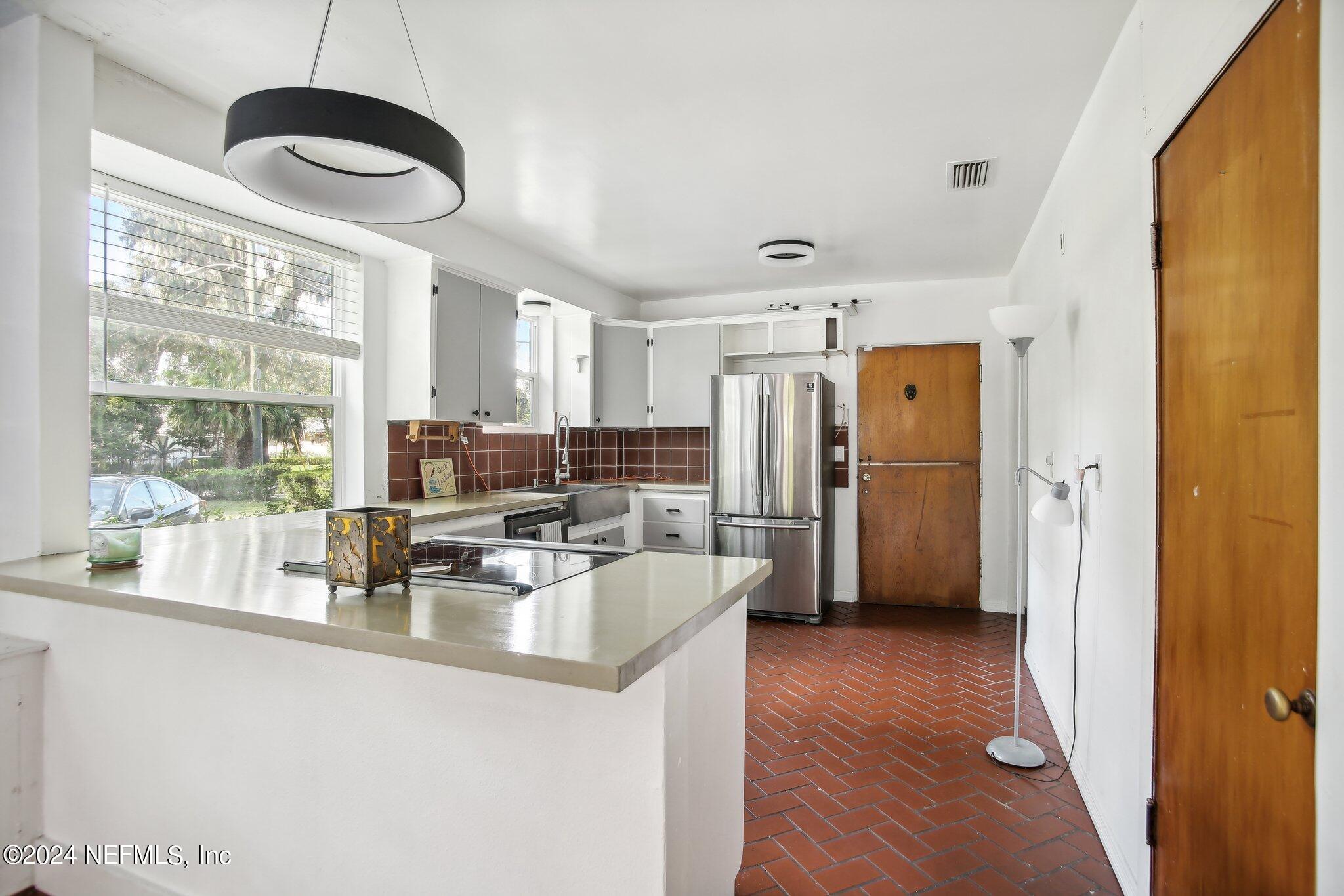 a kitchen with stainless steel appliances granite countertop a refrigerator and a stove top oven