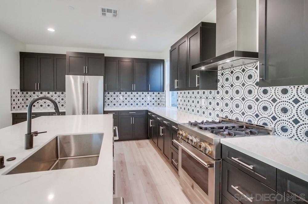 a kitchen with stainless steel appliances a stove a sink and a refrigerator