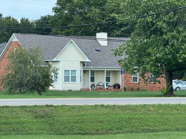 a front view of a house with a garden and trees