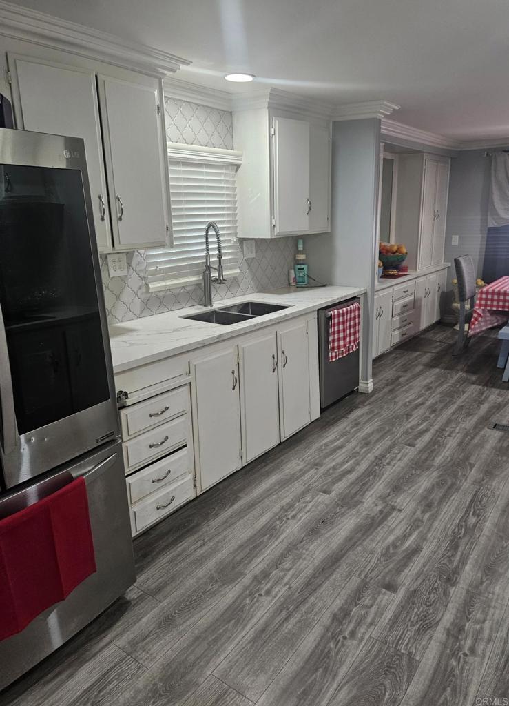 a kitchen with granite countertop a sink stove and cabinets