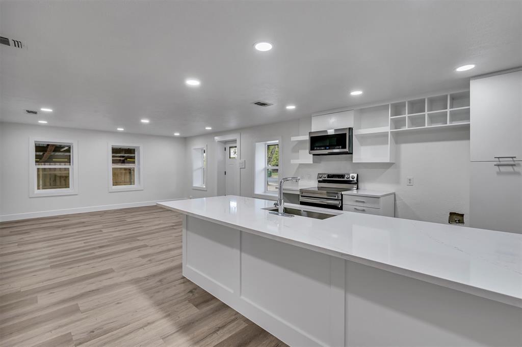 a kitchen with kitchen island a sink stainless steel appliances and cabinets