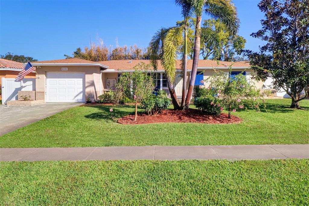 a front view of a house with a yard and potted plants