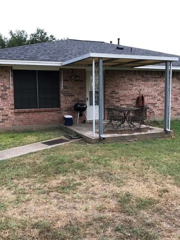 Back of house with a patio and a lawn