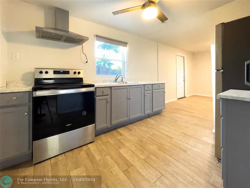 a kitchen with stainless steel appliances a stove a sink and a refrigerator