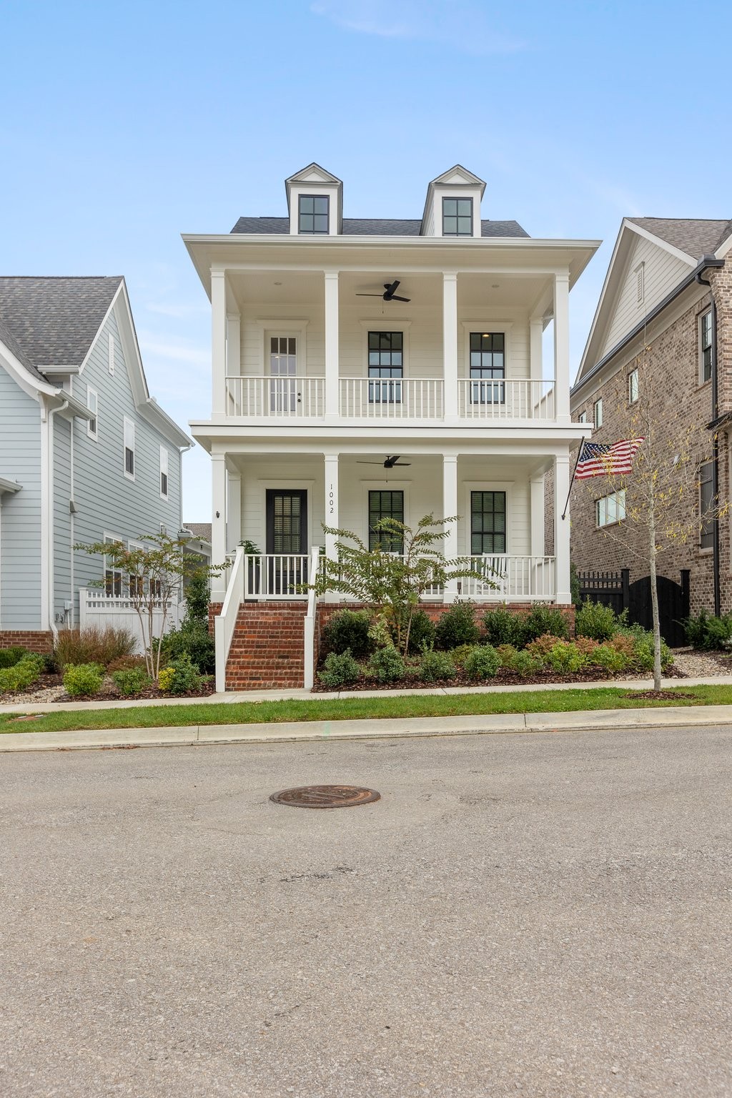 Welcome home to this timeless classic white house with black windows and double covered front porches!