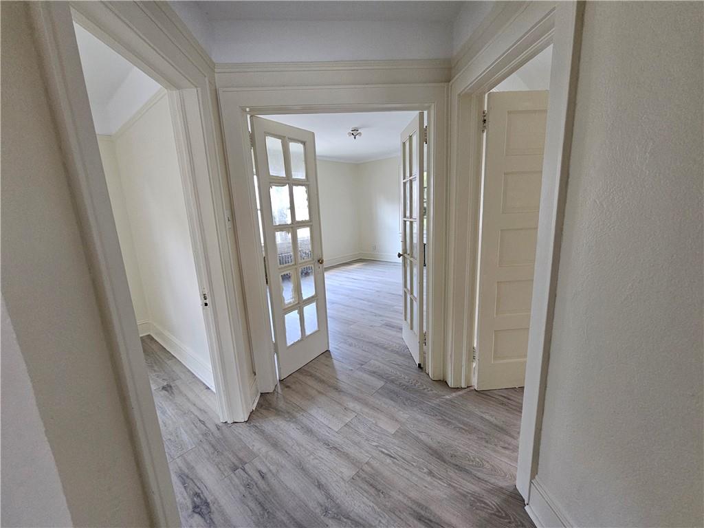 a view of a hallway with wooden floor and closet