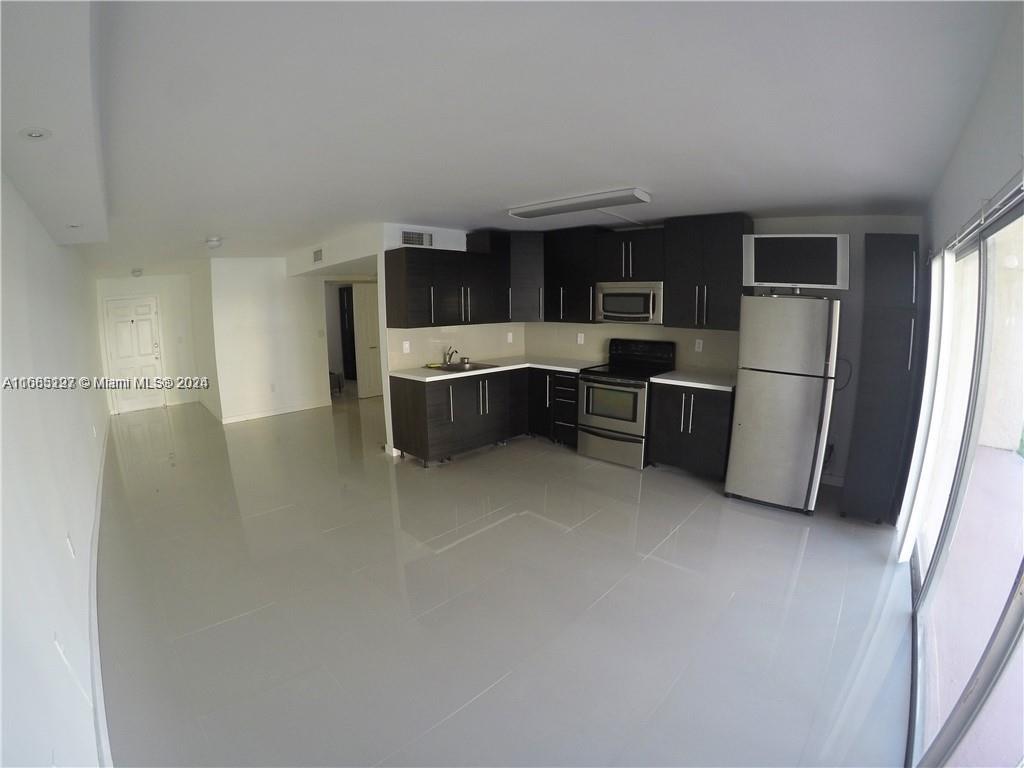 a kitchen with stainless steel appliances a refrigerator and a stove top oven