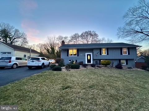 a view of a house with a big yard and parked cars