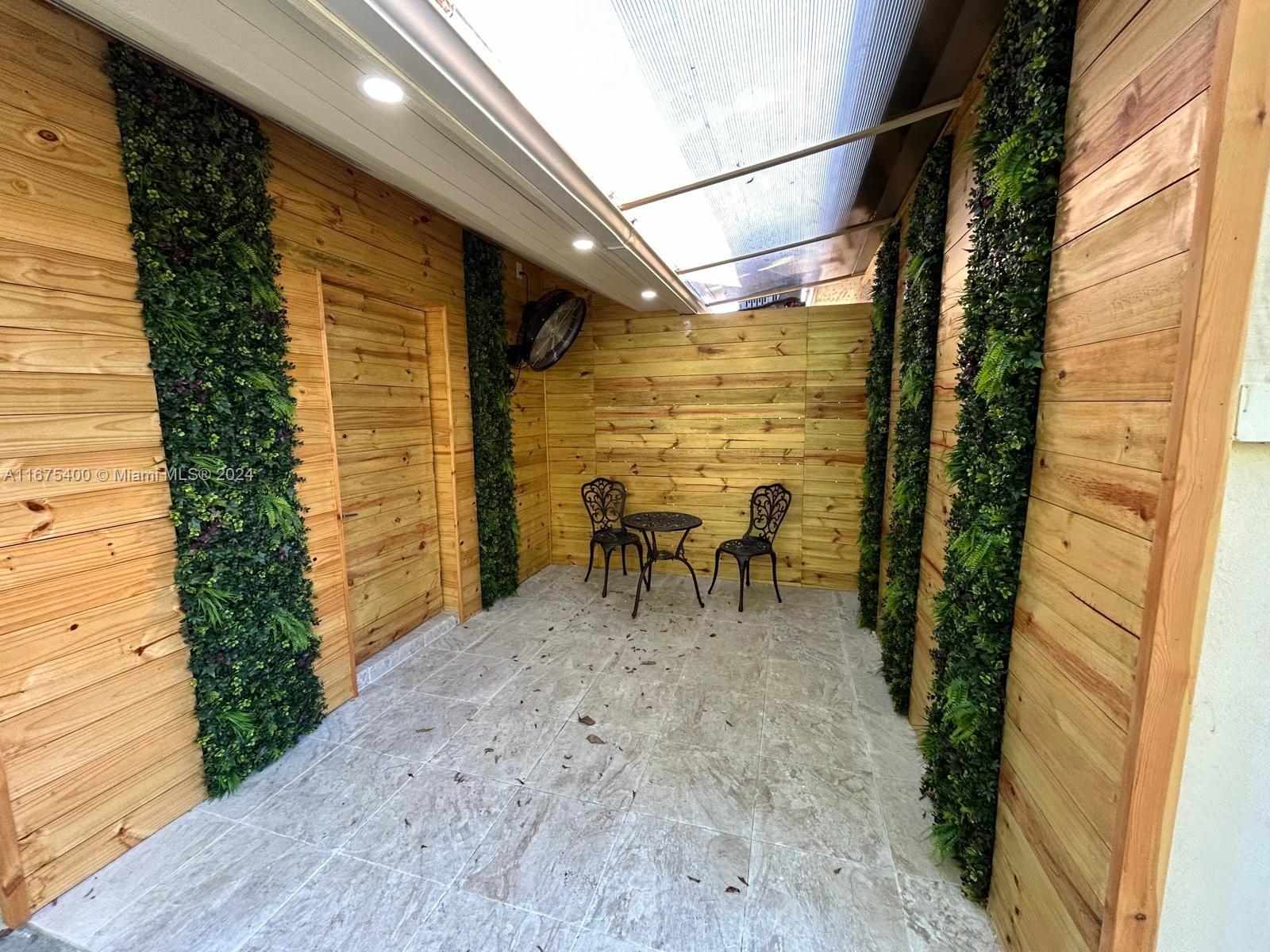 a view of a patio with a table and chairs and potted plants